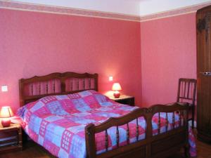 1 Schlafzimmer mit einem Bett mit rosa Wänden und 2 Stühlen in der Unterkunft Melabelle in Malandry