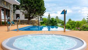 シュクラルスカ・ポレンバにあるGreen Park, Sun & Snowの庭園内の大型プール(ホットタブ付)