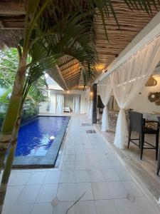 a swimming pool with a palm tree in a house at Villa deluna in Jimbaran