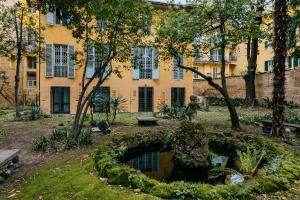 a garden in front of a building with a pond at Casa Ambrosini Apartments by Wonderful Italy in Bologna