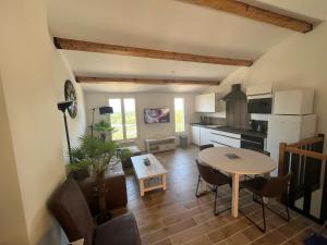 ein Wohnzimmer mit einem Tisch und einer Küche in der Unterkunft Mazet Bellevue in Cogolin