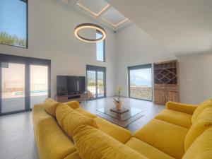 a living room with a yellow couch and a tv at Seaview Villa with pool-Vanja in Budva