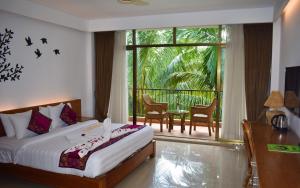 a bedroom with a bed and a balcony with a table at Dream Square Resort in Gazipur