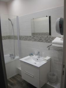 La salle de bains est pourvue d'un lavabo, d'une baignoire et d'un miroir. dans l'établissement La KEFOISE, à Fouquières-lès-Lens