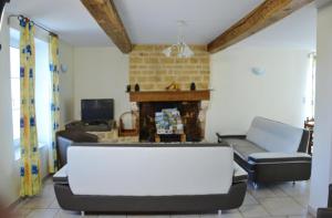 sala de estar con sofá y chimenea en La rosiere en Touligny