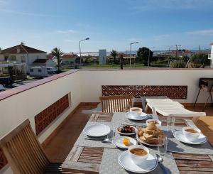 a table with plates of food on a balcony at T2 Baleal in Peniche