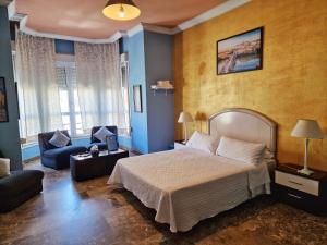1 dormitorio con 1 cama, 1 silla y 1 sofá en Apartamento El Duque - Plaza de las Tendillas, en Córdoba