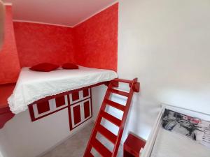a red room with a bunk bed and a ladder at I Coralli in Villasimius
