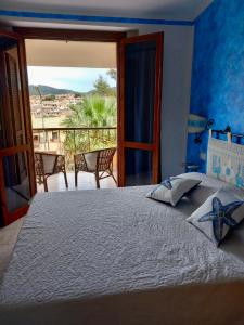 a bedroom with a bed with a view of a balcony at I Coralli in Villasimius