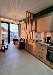 una cucina e un soggiorno con divano e tavolo di Midoya Sea View a Skaleta