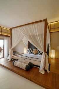 a bedroom with a bed with a canopy at IKIGAI Uluwatu Beach in Uluwatu