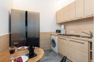 a kitchen with a table and a washer and dryer at Matejki-Lazurowy in Poznań +2 photos