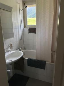 ein Badezimmer mit einem Waschbecken, einer Badewanne und einem Waschbecken in der Unterkunft Swiss Alpine Hideaway in Sedrun