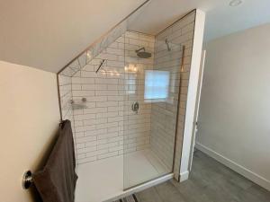 a shower with a glass door in a bathroom at Relaxez, condo Zen, climatisé, campagne&lacs in Magog-Orford +20 photos
