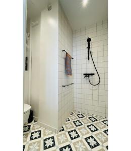 uma casa de banho com um chuveiro com azulejos pretos e brancos em ApartmentInCopenhagen Apartment 1548 em Copenhague