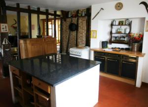 a kitchen with a black counter top in a room at Les mallinettes in La Neuville-aux-Joûtes +9 photos