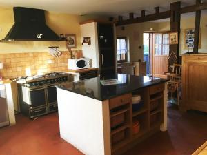 a kitchen with a stove and a counter top at Les mallinettes in La Neuville-aux-Joûtes