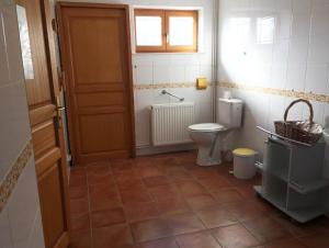 a small bathroom with a toilet and a door at Les mallinettes in La Neuville-aux-Joûtes