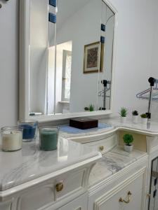 a white bathroom with a sink and a mirror at La Minicasa in Pacentro