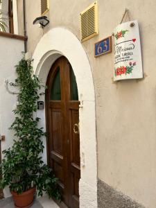 una puerta a un edificio con un cartel y una planta en La Minicasa en Pacentro