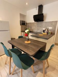 cocina con mesa de madera y algunas sillas en Appartement récemment rénové, en Saint-Léger