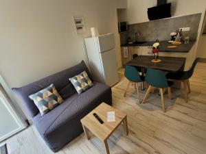 sala de estar con sofá, mesa y cocina en Appartement récemment rénové, en Saint-Léger