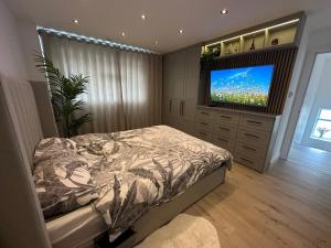 1 dormitorio con 1 cama y TV de pantalla plana en Luxury West London 3BR House, Cul De Sac, en Isleworth