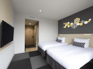 東京的住宿－宜必思尚品东京东银座酒店，酒店客房设有两张床和一台平面电视。