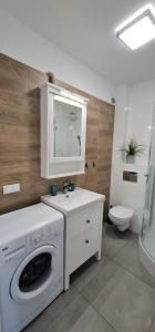 een badkamer met een wasmachine en een wastafel bij Apartamenty "u Jasia" I in Darlowko +47 foto's