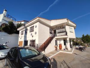 Un coche negro aparcado delante de un edificio en Casa los Huertecillos, en Nívar