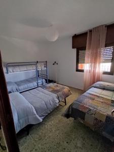 1 dormitorio con 2 camas y ventana en Casa los Huertecillos, en Nívar