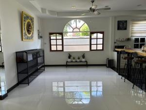 a living room with a white floor and a ceiling fan at Villa Happy home in Rawai Beach