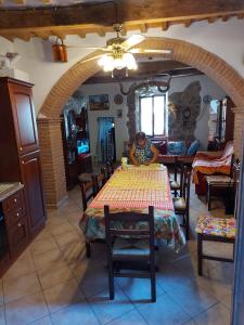 a woman sitting at a table in a room at Casa Santina in borgo medievale in Prata
