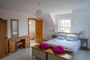 ein Schlafzimmer mit einem großen Bett mit lila Kissen in der Unterkunft Fairhead Lodge Family Friendly Holiday Home in Ballyvoy
