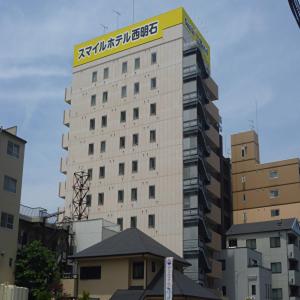 un edificio alto con un cartel encima en Smile Hotel Nishi-Akashi en Akashi