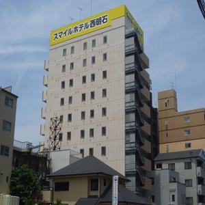 a tall building with a sign on top of it at Smile Hotel Nishi-Akashi in Akashi