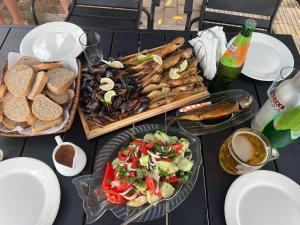a table topped with plates of food and a salad at Apart townhouse in K'obulet'i