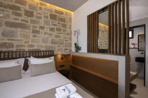 a bedroom with a bed and a stone wall at Balos Beach in Kissamos