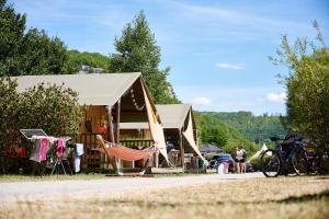 a tent with a hammock in front of it at Glamping Ornans in Ornans