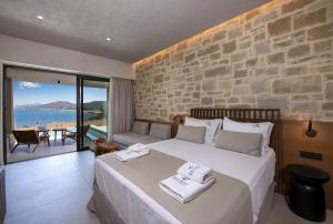 a bedroom with a large bed with a stone wall at Balos Beach in Kissamos