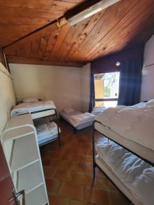 a room with three bunk beds and a wooden ceiling at Camping de Puyloubier in Puyloubier