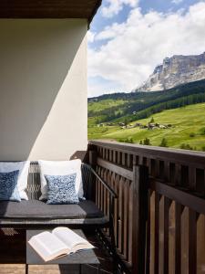 a bench on a balcony with a view of a mountain at Hotel La Majun in La Villa