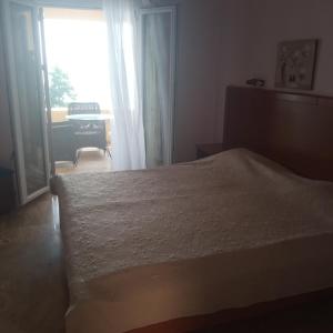 sypialnia z łóżkiem i oknem z pianinem w obiekcie Niki Sunrise Apartments w mieście Gastouri
