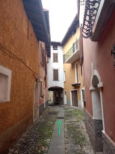 een steegje tussen twee gebouwen met een groene pijl erop bij Ca' del Portico in Valsolda