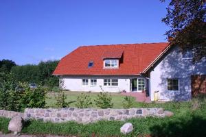 アルト・シュヴェリンにあるLandhaus Fischersruh Plauer Seeの赤屋根の大白屋敷