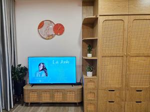 a flat screen tv sitting on top of a wooden dresser at Mây Homestay in Hanoi