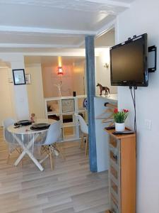 uma sala de estar com uma mesa e uma televisão na parede em Studio Chavigny avec wifi em Chavigny