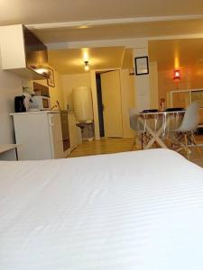een kamer met een wit bed en een keuken bij Studio Chavigny avec wifi in Chavigny