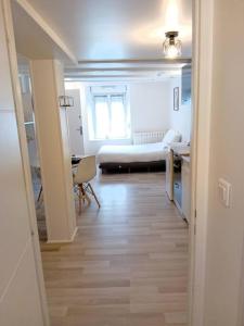 um corredor para uma sala de estar com um sofá e uma mesa em Studio Chavigny avec wifi em Chavigny