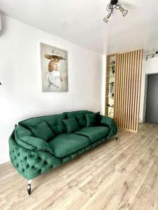 a green couch sitting in a living room at Apartament central 2 camere in Râmnicu Vâlcea